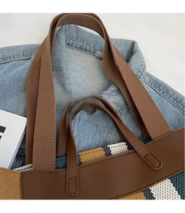 Detail of multi-color striped canvas tote bag with smooth faux leather long shoulder straps