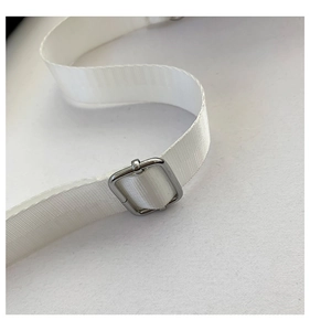 Detalle de la correa ajustable de nailon blanco con hebilla de metal plateado