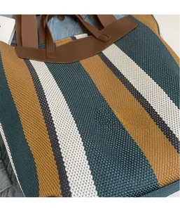 Detailed view of color block striped canvas tote bag with brown leather handles
