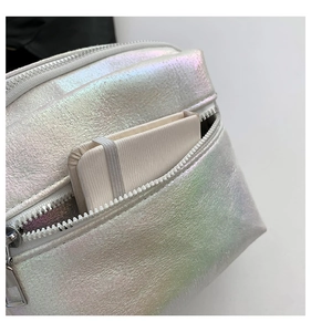Detalle del bolso bandolera iridiscente con doble cremallera y bolsillo frontal