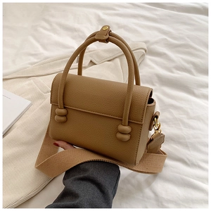 Détail du sac carré kaki avec poignée à nœud sphérique et large bandoulière en tissu