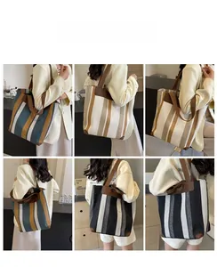 Detail view of large canvas tote bag with contrast stripes and durable leather handles