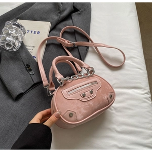 Pink mini motorcycle handbag with silver rivets and studs on a minimalist white background