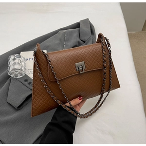Detail der gewebten braunen Ledertasche mit Metallkette und Vintage-Viereck-Schnalle