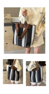 Detail of large striped canvas tote bag with brown leather straps and reinforced corners