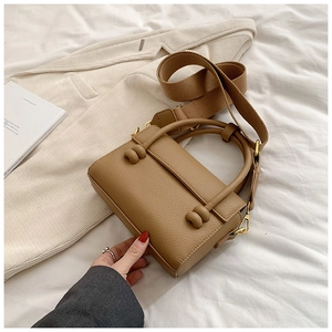 Détail du sac en cuir grainé kaki avec bandoulière large et finitions dorées chic
