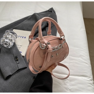 Pink round faux leather handbag featuring silver metal studs and chain strap detail