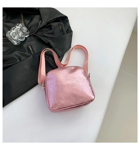 Detalle del bolso bandolera rosa metalizado con una moderna correa ancha de tela