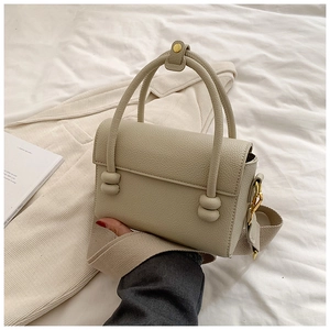 Détail du sac à main crème en cuir grainé avec une large bandoulière en tissu doux