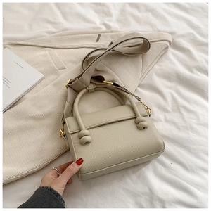 Détails du sac à main crème avec texture litchi, nœuds décoratifs et boucles métalliques dorées