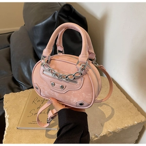 Detail of pink mini round handbag featuring silver chains, biker rivets, and retro leather