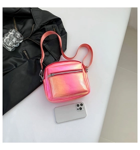 Detalle de bolso bandolera rosa holográfico con doble cremallera y correa ancha