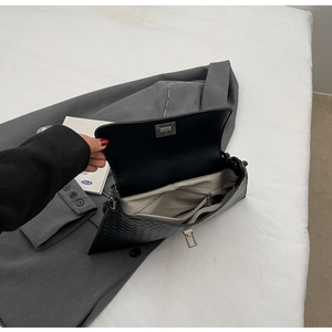 Innenansicht einer schwarzen gewebten Ledertasche mit grauem Futter und Reißverschlussfach
