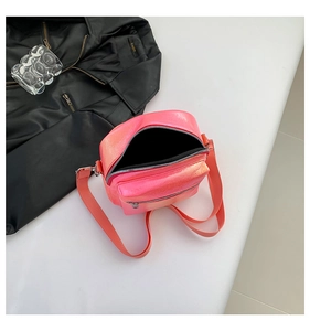 Vista superior de un bolso bandolera rosa metalizado con compartimentos de cremallera