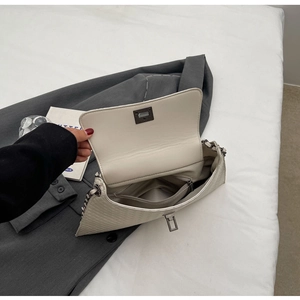 Detailansicht der cremefarbenen Stepptasche mit Innentasche und Metallkettenriemen