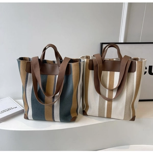 Close-up of contrast striped canvas tote bags with leather trim and double straps