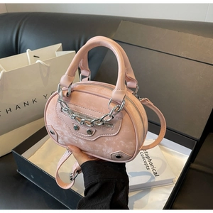 Detail of pink mini tote bag with silver chain and studs in a luxury gift box setting