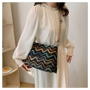 Détail du sac seau bohème en laine avec motifs à vagues et large bandoulière tissée