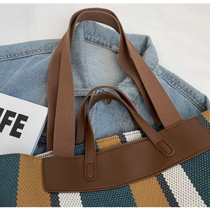 Detail view of the multi-color striped canvas tote bag with brown leather handles and straps