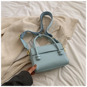 Détails du sac à main bleu clair en cuir avec bandoulière large et boucles dorées