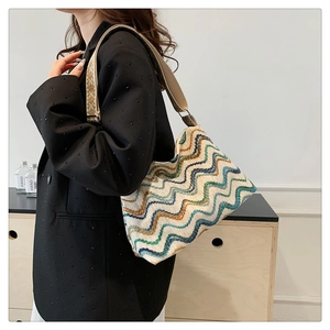 Détail du sac seau en maille bohème avec motifs à vagues colorés et large bandoulière