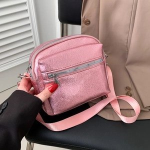 Bolso bandolera rosa metalizado con bolsillos dobles de cremallera en silla