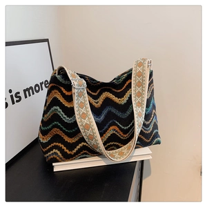 Détail d'un sac bohème en tricot avec motifs de vagues colorées et bandoulière jacquard
