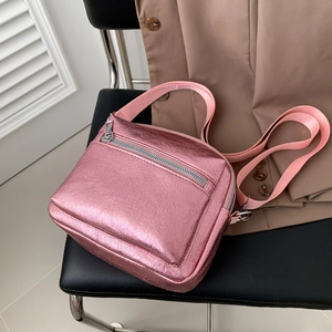 Bolso bandolera cuadrado rosa metalizado moderno con correa de tela en silla