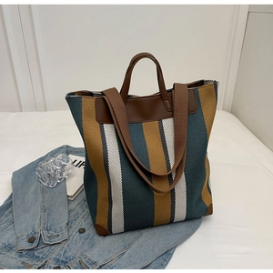 Detail of striped canvas tote bag with leather reinforcement and dual shoulder straps