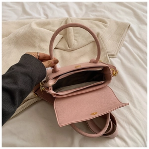 Vue détaillée du sac rose en cuir synthétique montrant l'intérieur et les détails dorés