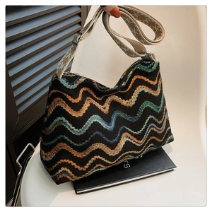 Détail du tricot ondulé bohème coloré et bandoulière tissée réglable sur le sac hobo