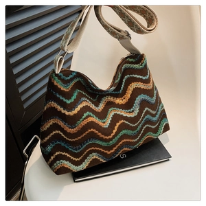 Détail du sac seau en maille bohème avec motifs de vagues et large bandoulière ethnique