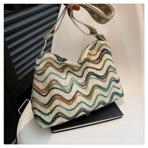 Détail d'un sac à bandoulière en laine bohème avec motifs de vagues et sangle jacquard