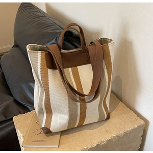 Detail showing high-quality canvas stripes and leather trim on a vintage tote bag