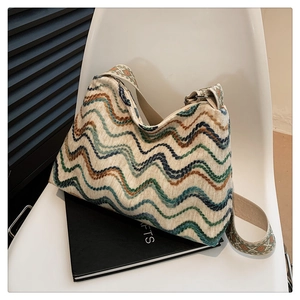 Détail d'un sac bohème en tricot à motifs ondulés avec large bandoulière et zip