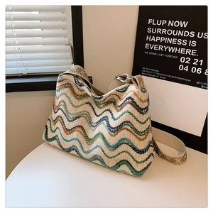 Détail d'un sac seau bohème en tricot avec motifs à vagues et large bandoulière ethnique