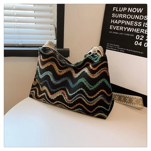 Détail d'un sac bohème en laine avec motifs à vagues et bandoulière ethnique brodée