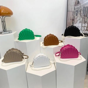 Detailed view of shell-shaped PU leather handbags in six trendy candy colors with straps
