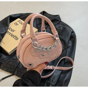 Detail of light pink mini bag with silver chain and rivets on black leather jacket