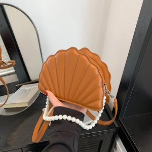 Detail of caramel PU shell bag with pearl handle and pleated texture design