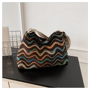 Détail du sac bohème en laine tricotée montrant des motifs ondulés et une large bandoulière