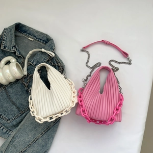 Flat lay of pink and white pleated PU leather handbags with chunky chain details