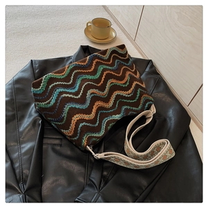 Détail du sac seau en tricot bohème avec motifs à vagues colorées et bandoulière jacquard
