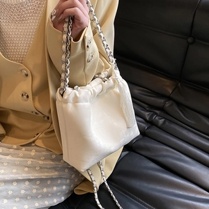 Detail der cremefarbenen Wolken-Tasche mit Silberkette und langer dekorativer Seidenquaste