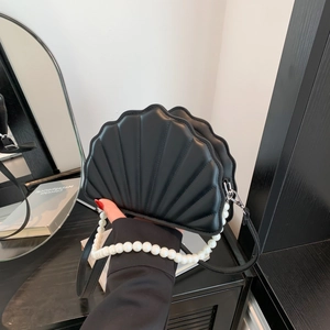 Detailed close-up of a black shell-shaped PU handbag with a decorative pearl handle