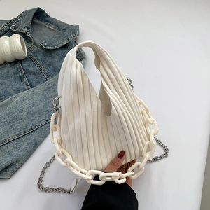 Detailed close-up of white pleated cloud bag with resin and silver metal chain straps