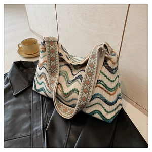 Détail du sac seau en laine bohème avec motif ondulé coloré et bandoulière ethnique