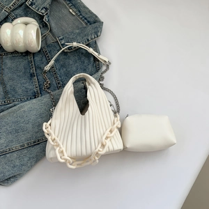 Detail of pleated PU leather bag with decorative resin chain and matching small pouch