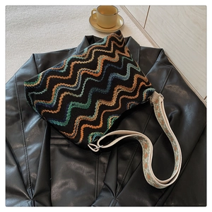 Détail d'un motif tricoté coloré sur un sac bohème avec bandoulière tissée large