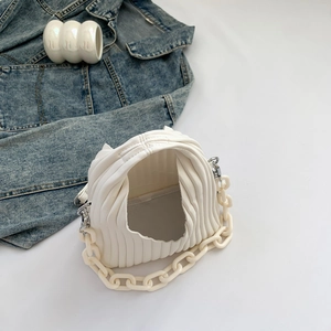 Detailed close-up of a white cloud bag with wave textures and a chunky chain handle